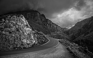 black and gray photo of road across mountains