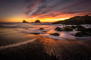 cloudy sky over rocks on shore