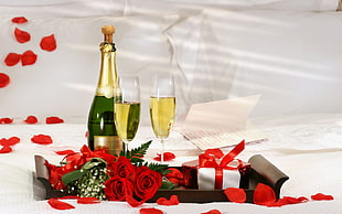 wine bottle beside glasses and Rose flower on table