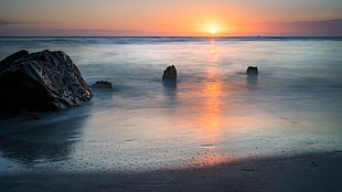 landscape photography of ocean with stone formations during golden hour, madeira beach, florida