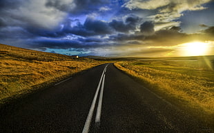 black road beside grass field, road, sunlight, landscape, clouds