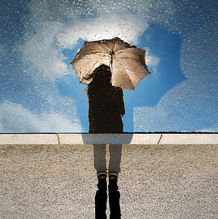 woman holding brown umbrella during sunrise HD wallpaper
