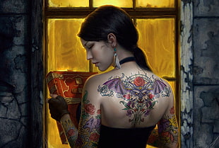 black haired woman with purple and red bat with flower tattoo on her back