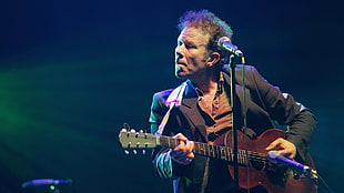man playing guitar in front of microphone