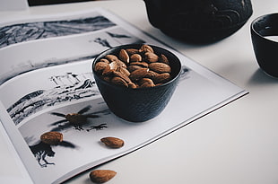 almond nuts and black ceramic bowl