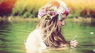 woman wearing white top and flowers crowns in bodies of water