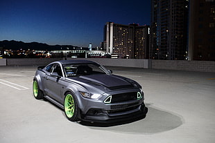 gray Ford Mustang parked on concrete surface during night time HD wallpaper