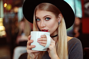 selective focus photography of woman holding mug HD wallpaper