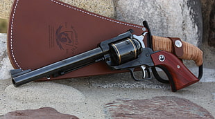 black revolver with brown leather holster