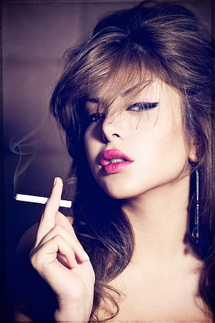 woman with pink lipstick and black eyeliner holding cigarette portrait