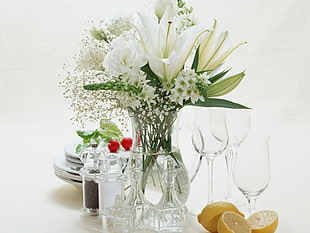 white Lily flowers in clear vase bear wine glasses