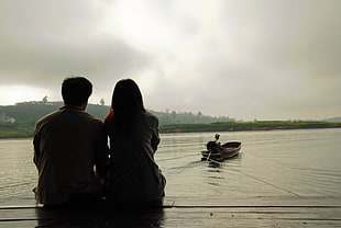 couple sitting near on river HD wallpaper