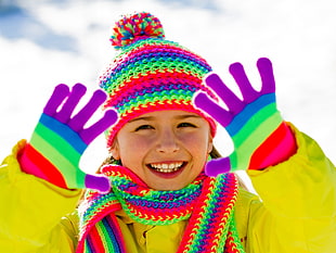 girl wearing multi-colored knit cap and gloves