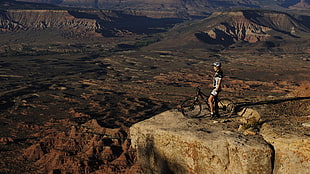 person riding on black bicycle on top of the mountain
