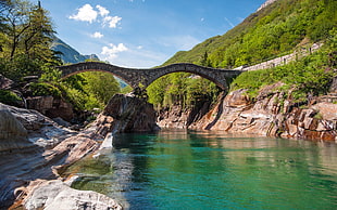 landscape photo of concrete arc bridge under river near on mountains during daytime HD wallpaper
