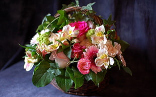 pink and white artificial flowers with basket