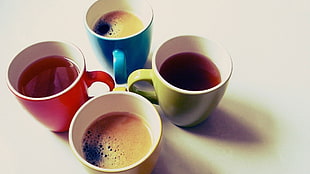 green, blue, red and yellow ceramic mugs