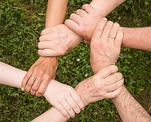 group of people holding each others wrist