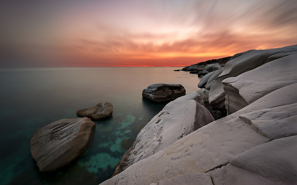 gray rocks near body of water during sunset HD wallpaper