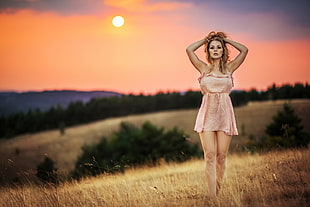 woman wearing brown spaghetti strap dress on brown grass field
