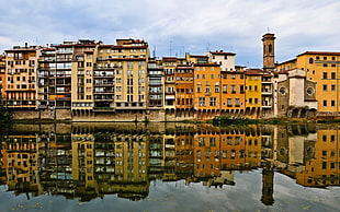 buildings reflecting on body of water during daytime