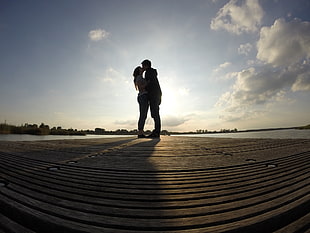 silhouette of man and woman in wooden dock HD wallpaper
