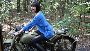 woman wearing blue long-sleeved shirt riding on motorcycle