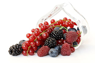 cherries, raspberries and blackberries in clear glass bowl