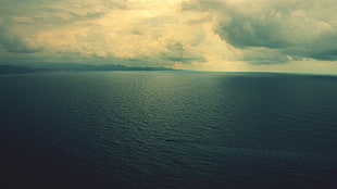 photography of sea under clouds