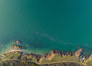 aerial photography of mountain near shoreline during daytime