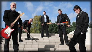 photograph of a band wearing black suits