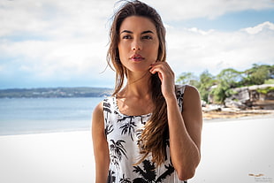 women's wearing white and black palm print sleeveless top near beach seashore during daytime