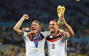 soccer players holding trophy