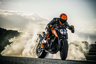 man riding on orange and black sports bike under white sky during daytime HD wallpaper