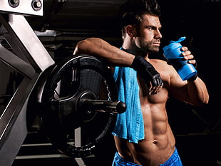 man holding blue plastic tumbler beside black gym plate HD wallpaper