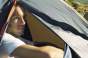 man wearing white t-shirt in black and gray camping tent