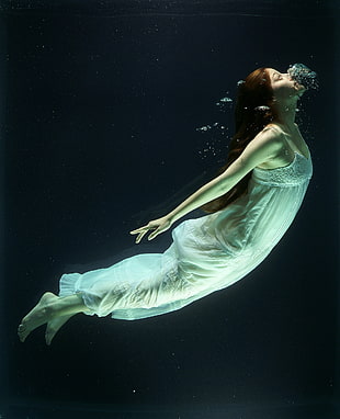 woman in white cami dress underwater