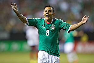 macro shot photography of Soccer player wearing green Adidas 8 soccer jersey