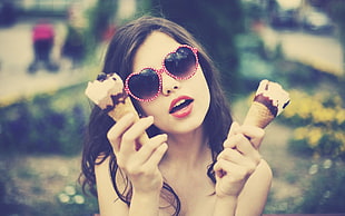 woman holding two ice creames