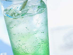 closeup photo of glass container filled with green liquid with ice