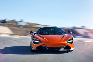 time-lapse photography of orange sports car on road during daytime