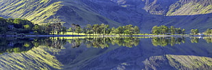 landscape reflection photography of body of water and green trees in front of mountain