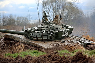 gray military tank surrounded by green grass