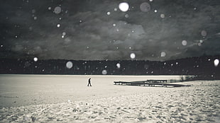 man walking on snow covered field