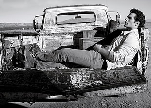 gray scale photo James Dean lying on pickup truck bed