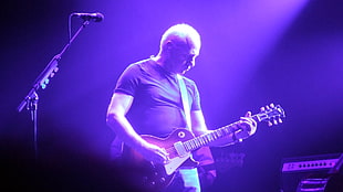 man wearing black t-shirt playing guitar on stage HD wallpaper