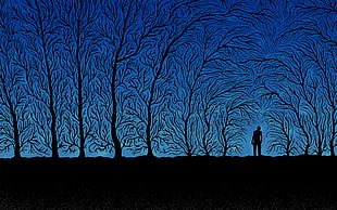 person standing between trees painting