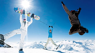 three men playing snowboarding during daytime