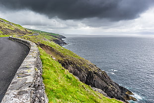 landscape photography of road near cliff, dingle, dunquin, kerry, ireland