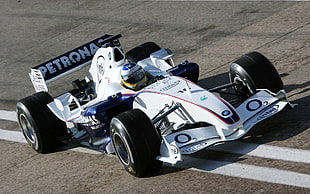 person driving a white and blue BMW Petronas Formula 1 car during daytime